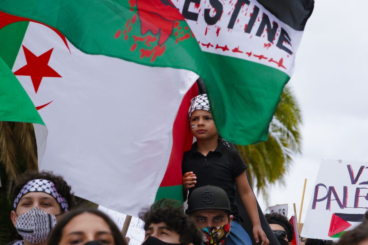 Mohammed Afad sits on the shoulders of cousin Ahmed Abuziad at a pro-Palestinian rally May 15 in San Diego's Balboa Park.