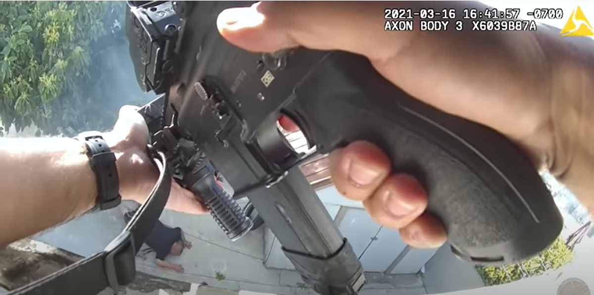 Body-camera footage shows close up of officer's hands holding a weapon pointed at a man lying face down on the ground
