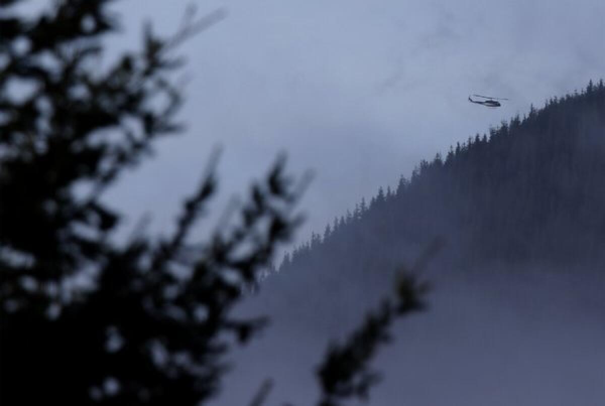 A King County Sheriff's Office helicopter flies over rugged terrain around Mount Si near North Bend, Wash., where searchers were looking for missing skydiver Kurt Ruppert of Florida.