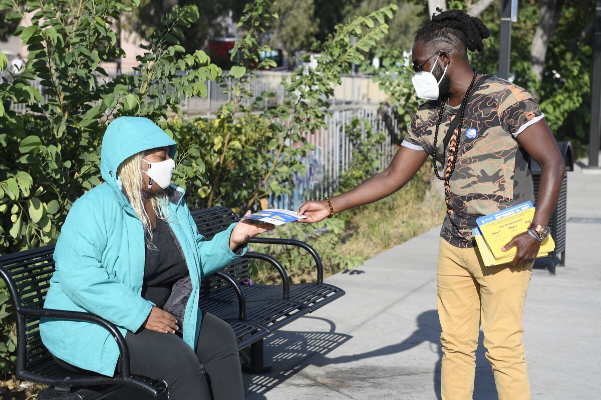 Prince Sefa-Boakye, NAACP San Diego, hands out election literature near Jacobs Center September 9, 2021 in San Diego. 
