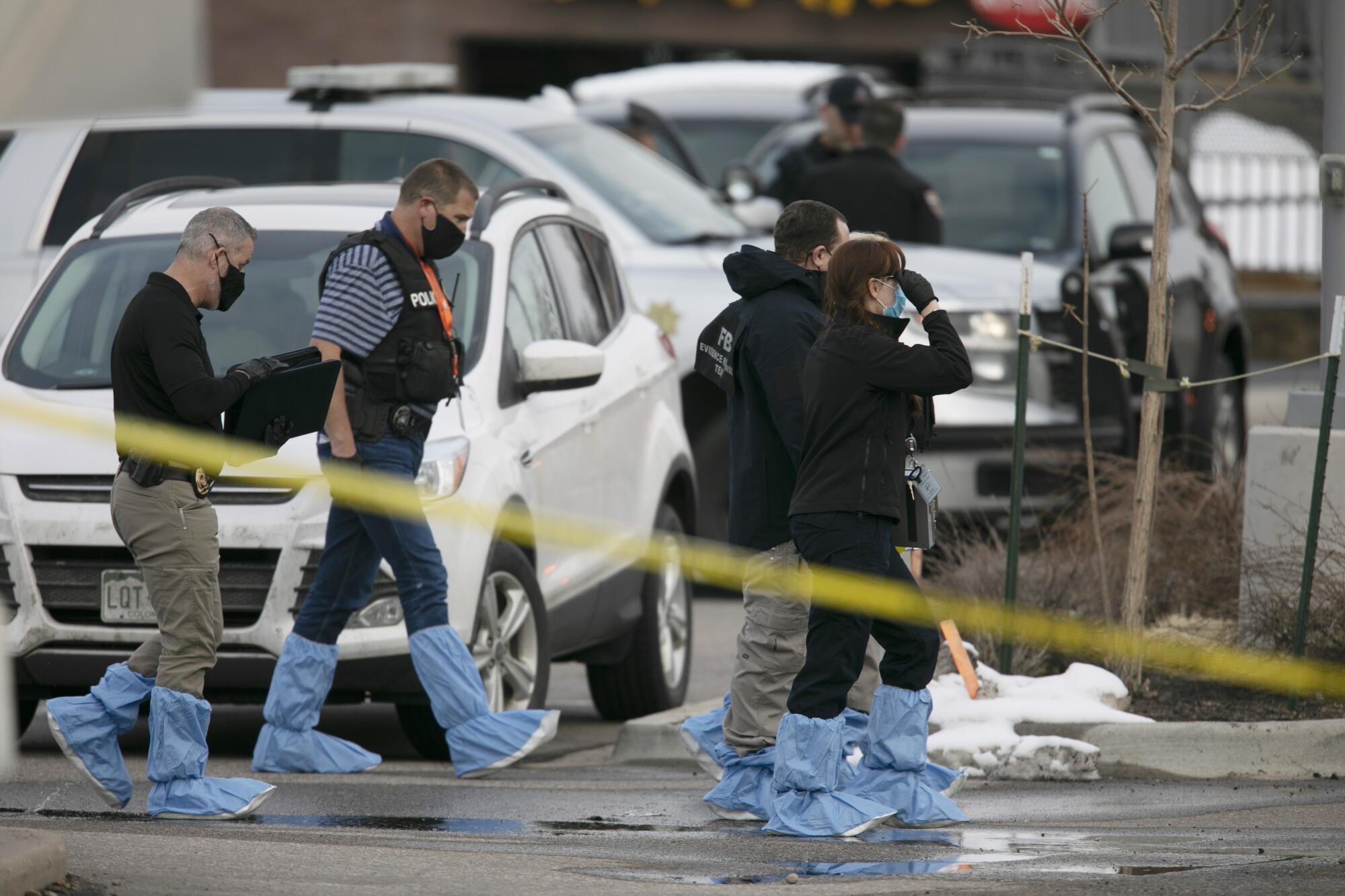 Police work on the scene outside of a King Soopers grocery store where a shooting took place Monday