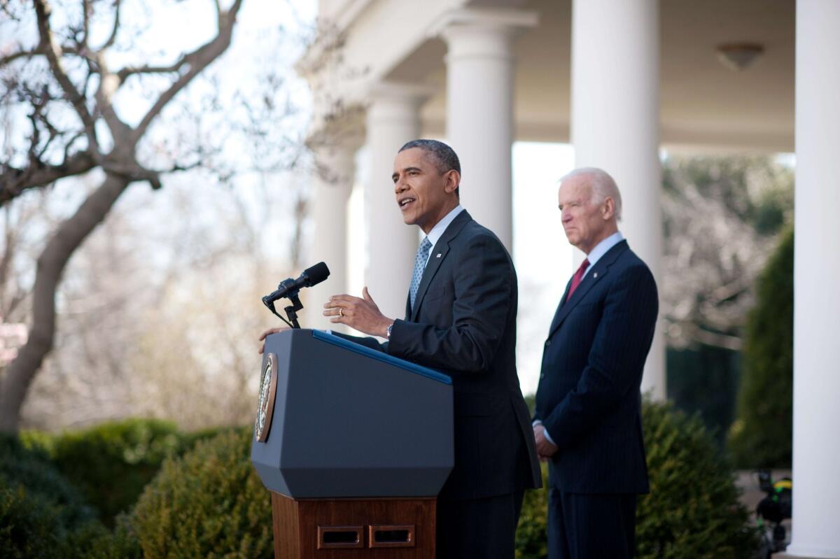 President Obama touts the Affordable Care Act, saying 7.1 million people have signed up, as Vice President Joe Biden listens in the White House Rose Garden.