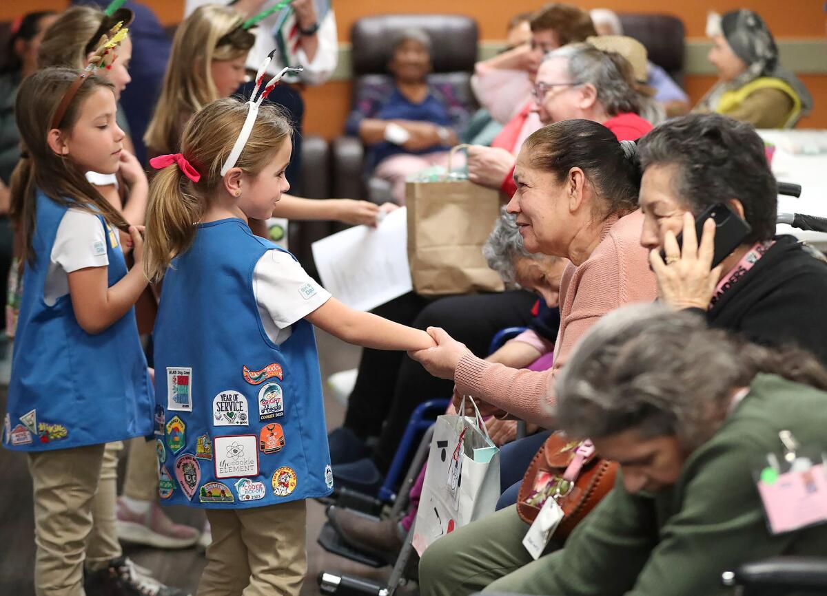 Girl Scouts deliver holiday gift bags to seniors at the Santa Ana Adult Day Health Care Center.