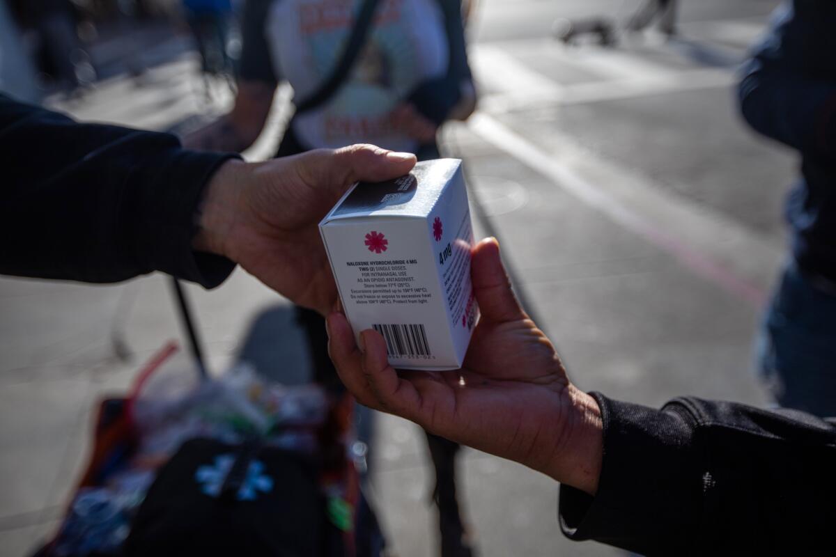 Volunteers from the Sidewalk Project hand out boxes of Narcan to reverse opioid overdoses in Los Angeles.