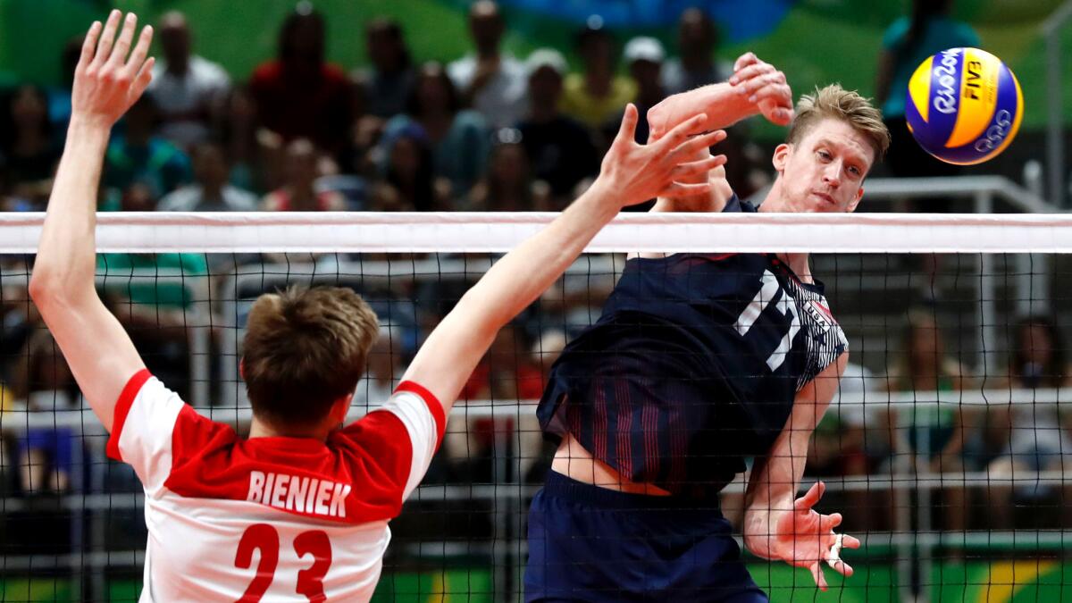 American Maxwell Holt spikes the ball past Poland's Mateusz Bieniek during their match Wednesday.