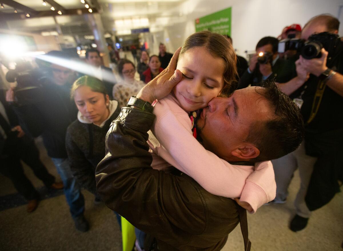 Esvin Fernando Arredondo embraces his daughter, Alison Arredondo, at Los Angeles International Airport