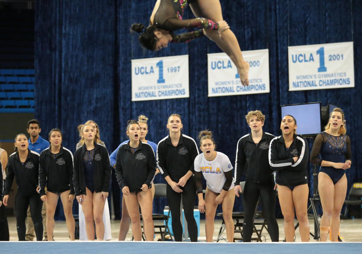 Teammates shout support during Felicia Hano’s floor exercise. The team held an exhibition as part of the UCLA's Meet the Bruins day.
