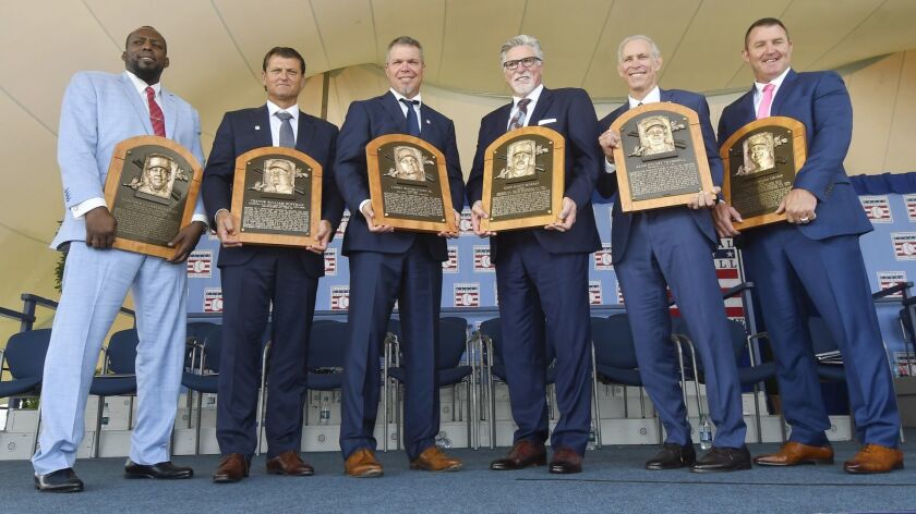 Baseball Hall of Famers from left, Vladimir Guerrero, Trevor Hoffman, Chipper Jones, Jack Morris, Alan Trammell, and Jim Thome, hold their plaques after an induction ceremony at the Clark Sports Center on Sunday, July 29, 2018, in Cooperstown, N.Y.