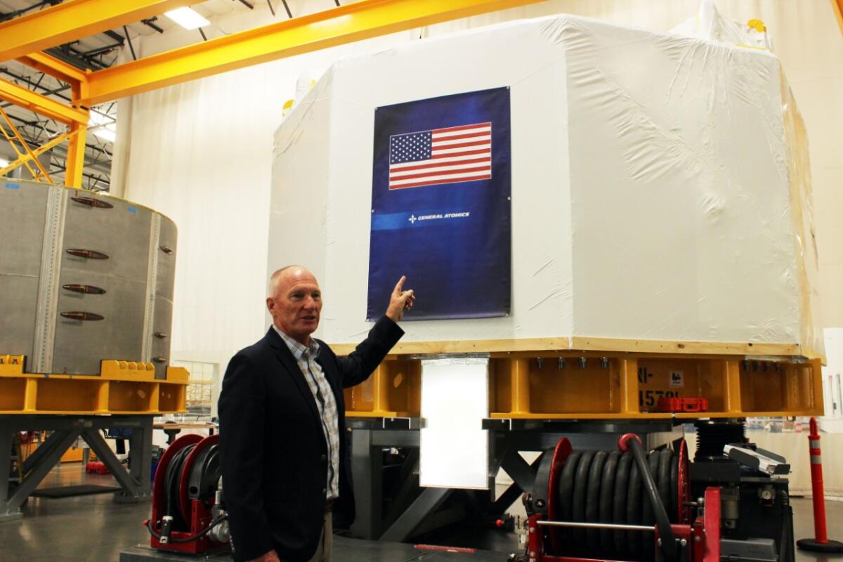 John Smith of General Atomics points to a module 