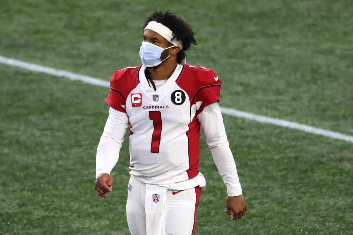 Arizona Cardinals quarterback Kyler Murray wears a mask while walking off the field.
