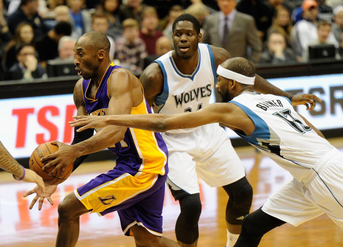 Lakers guard Kobe Bryant drives by Timberwolves forward Anthony Bennett and guard Corey Brewer in the first half.