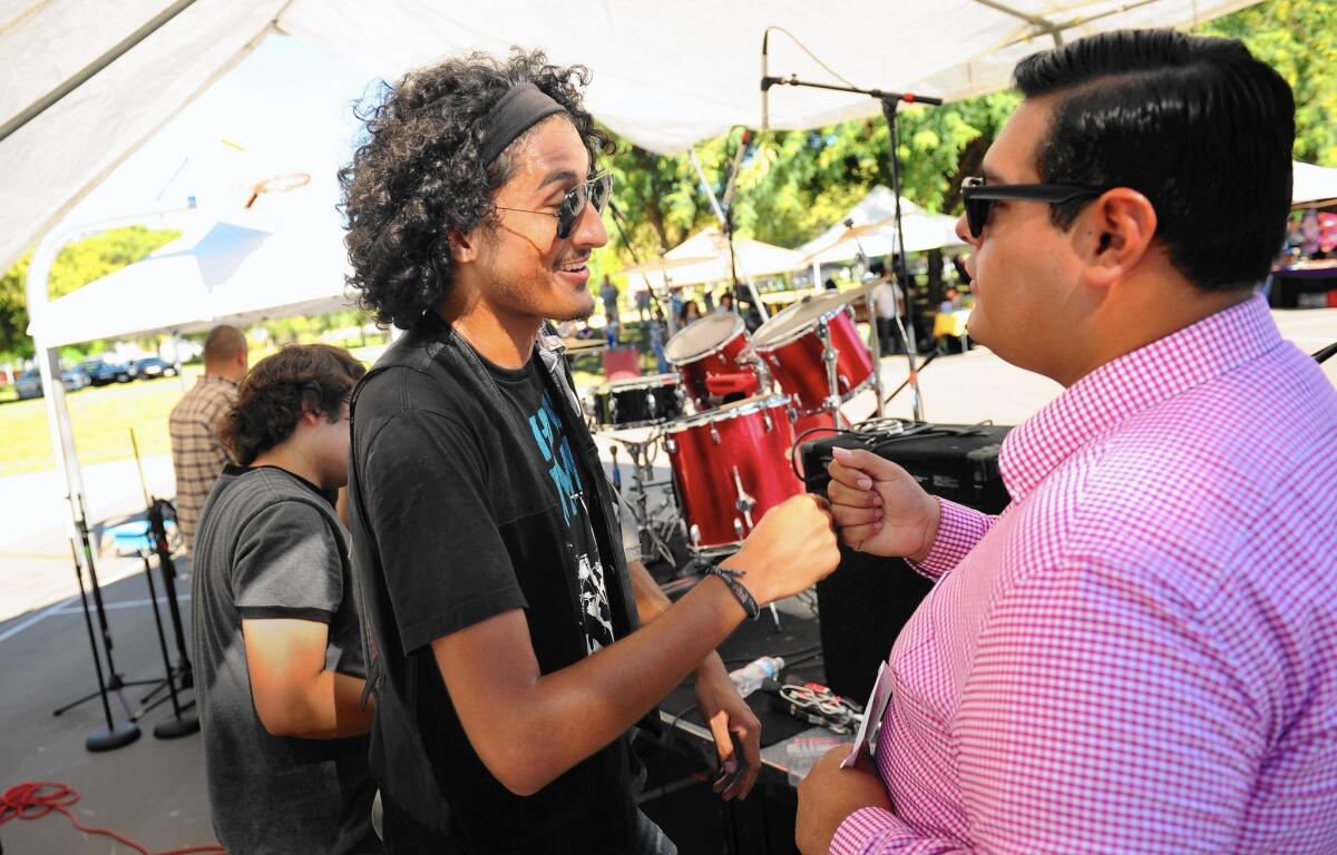 Maywood Music Festival organizer Jonathan Jimenez, left, thanks a member of the group Whiskey Dynamos after the concert.