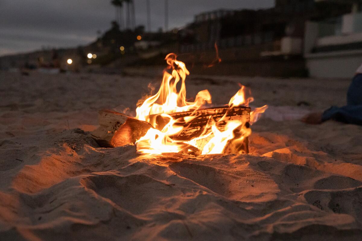 A small wood fire burns on the beach at La Jolla Shores on Aug. 26.