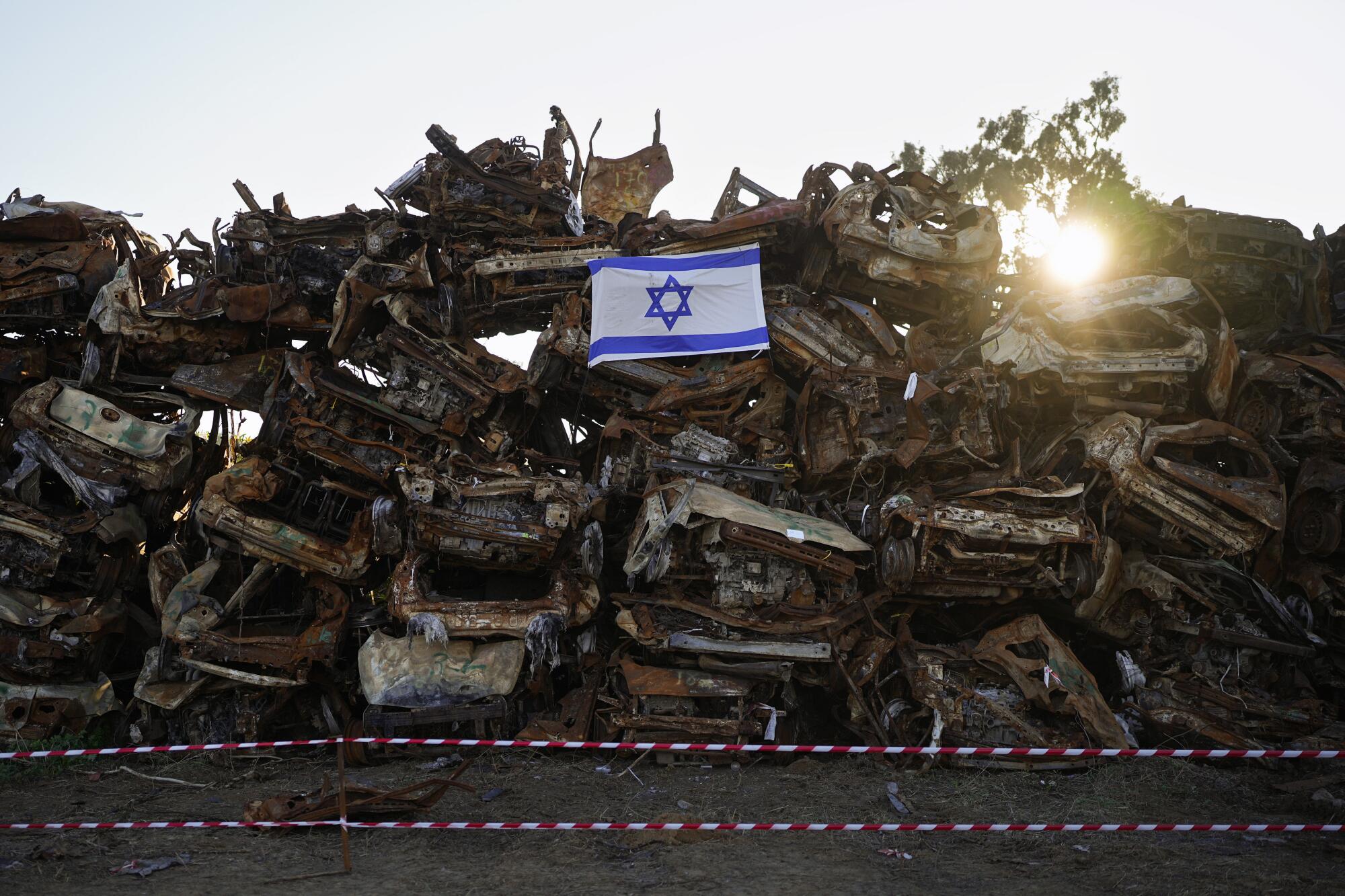 Israeli flag on pile of charred vehicles