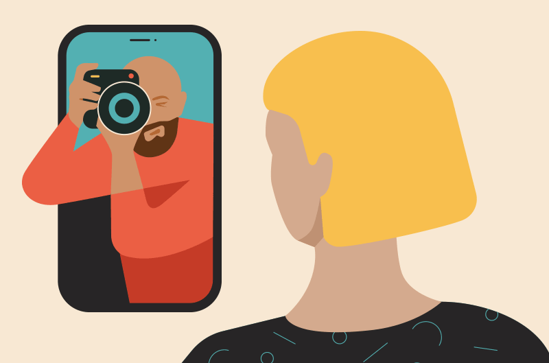 A woman looks at a photographer holding a camera inside phone.