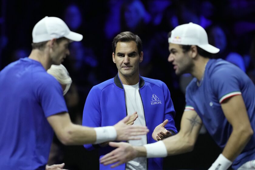 Team Europe's Roger Federer, center, looks at Andy Murray, left, and Matteo Berrettini during a match against Team World's Jack Sock and Felix Auger-Aliassime on final day of the Laver Cup tennis tournament at the O2 in London, Sunday, Sept. 25, 2022. (AP Photo/Kin Cheung)