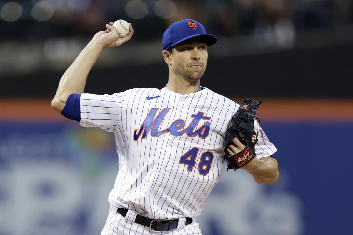 Mets pitcher Jacob deGrom throws to first base.