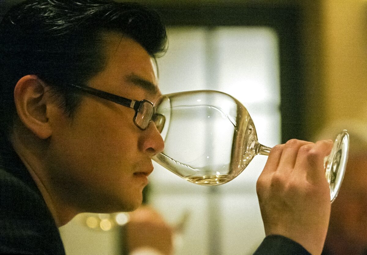 Rudy Kurniawan holds a wine glass to his nose