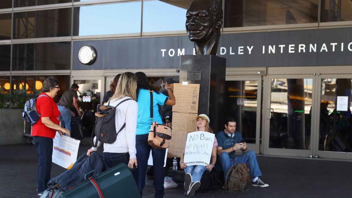 People protesting President Trump's travel ban greet travelers at the Tom Bradley International Terminal at LAX on Monday.