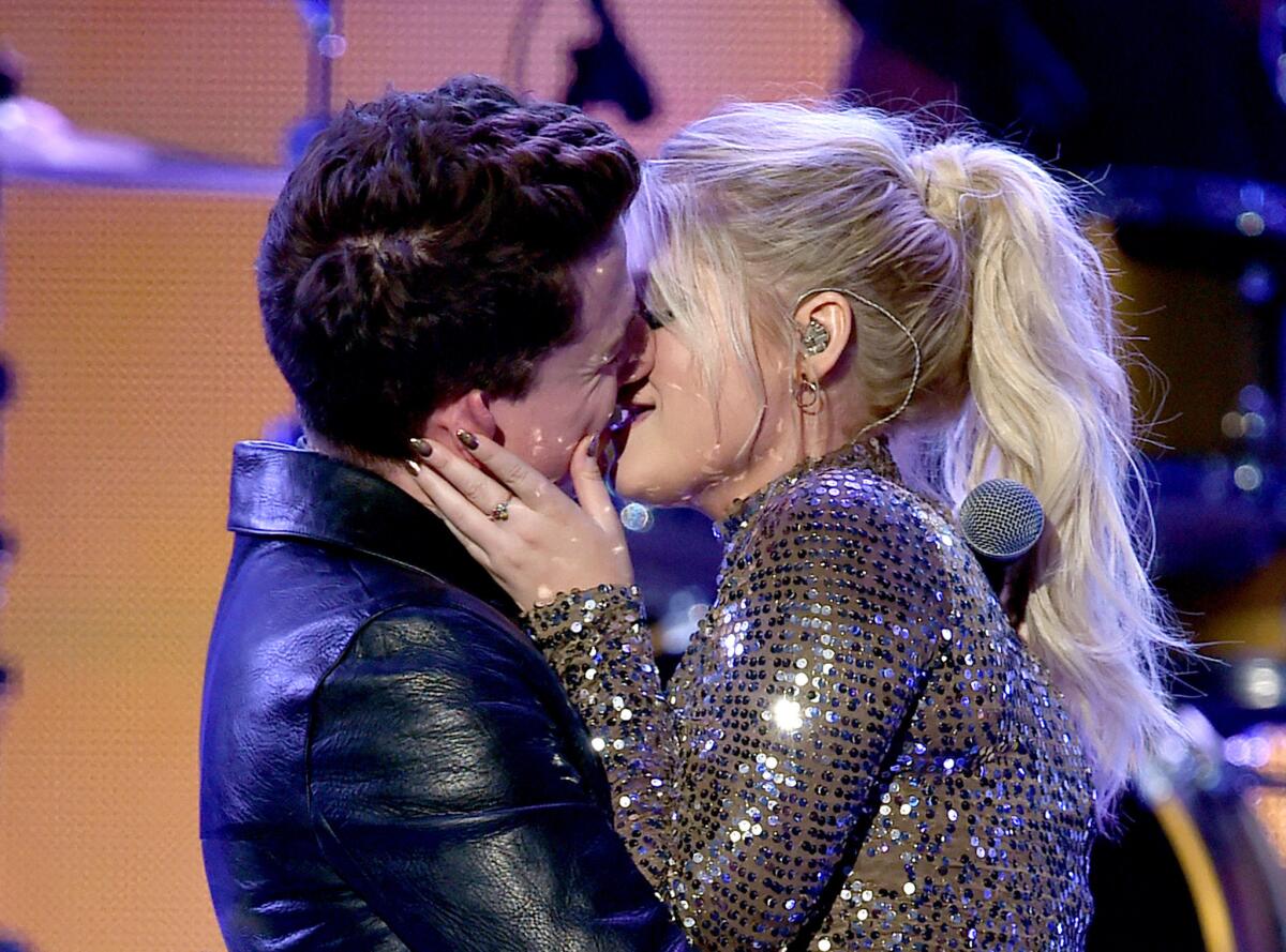 Singers Charlie Puth and Meghan Trainor kiss onstage, something they've done before.