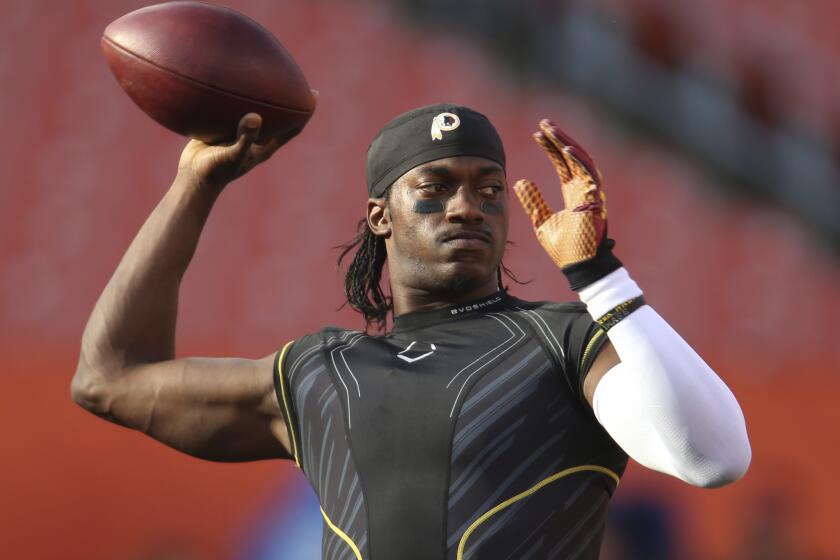 Robert Griffin III warms up with the Washington Redskins before a preseason game against the Cleveland Browns on Aug. 13.