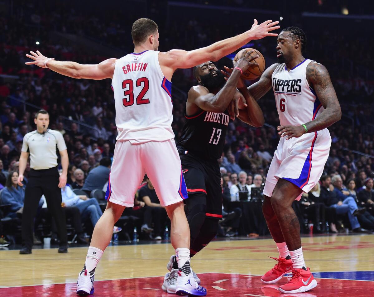 Rockets guard James Harden tries to drive to the basket between Clippers big men Blake Griffin (32) and DeAndre Jordan (6) during the first half.