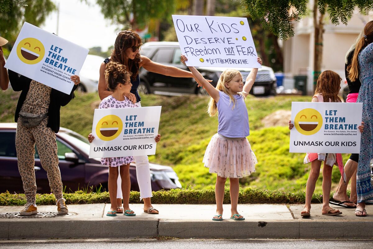 Adults and children with Let Them Breathe, an anti-mask group, protest at the Redondo Beach school district building in July.