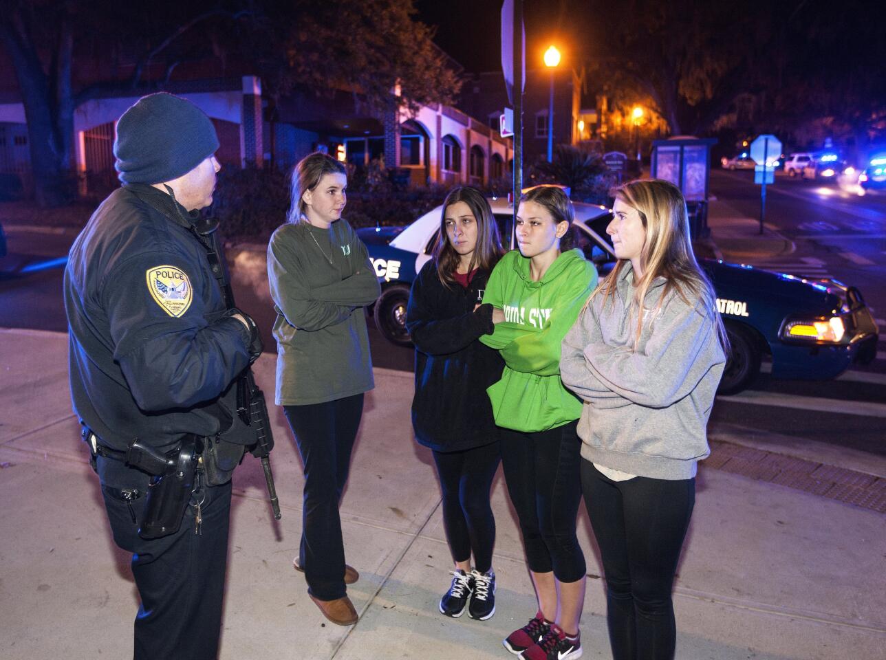 A Tallahassee police officer talks to students outside Strozier Library after the shooting on the Florida State University campus.