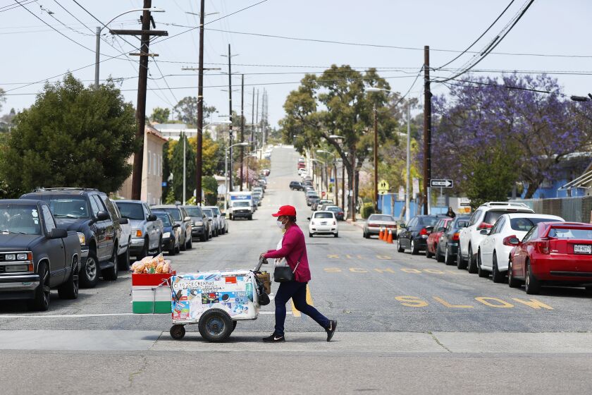 , CA - MAY 11: Pushcart vendor Cleotilde Dimas walks through a Logan Heights neighborhood on Tuesday, May 11, 2021 in , CA. (K.C. Alfred / The San Diego Union-Tribune)