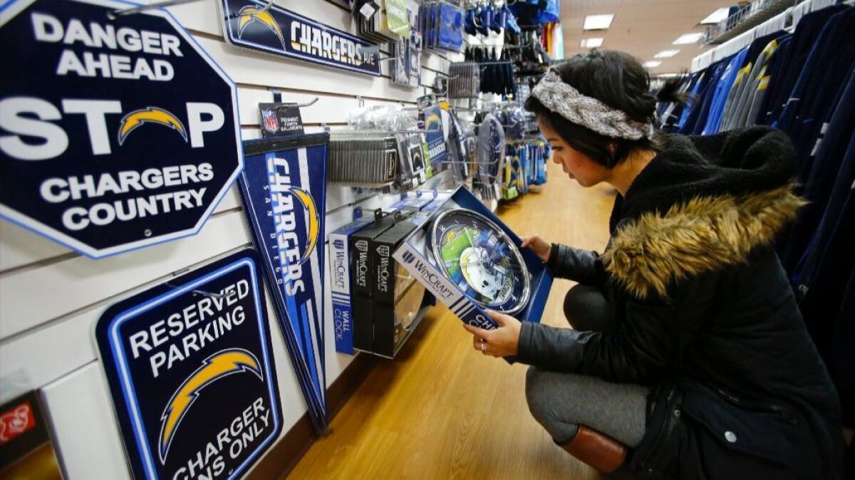 Amelia Yeh of Ocean Beach looks at a Chargers-themed clock while visiting the Sports Fever store in the Westfield Mission Valley mall. The majority of their business is related to the Chargers.