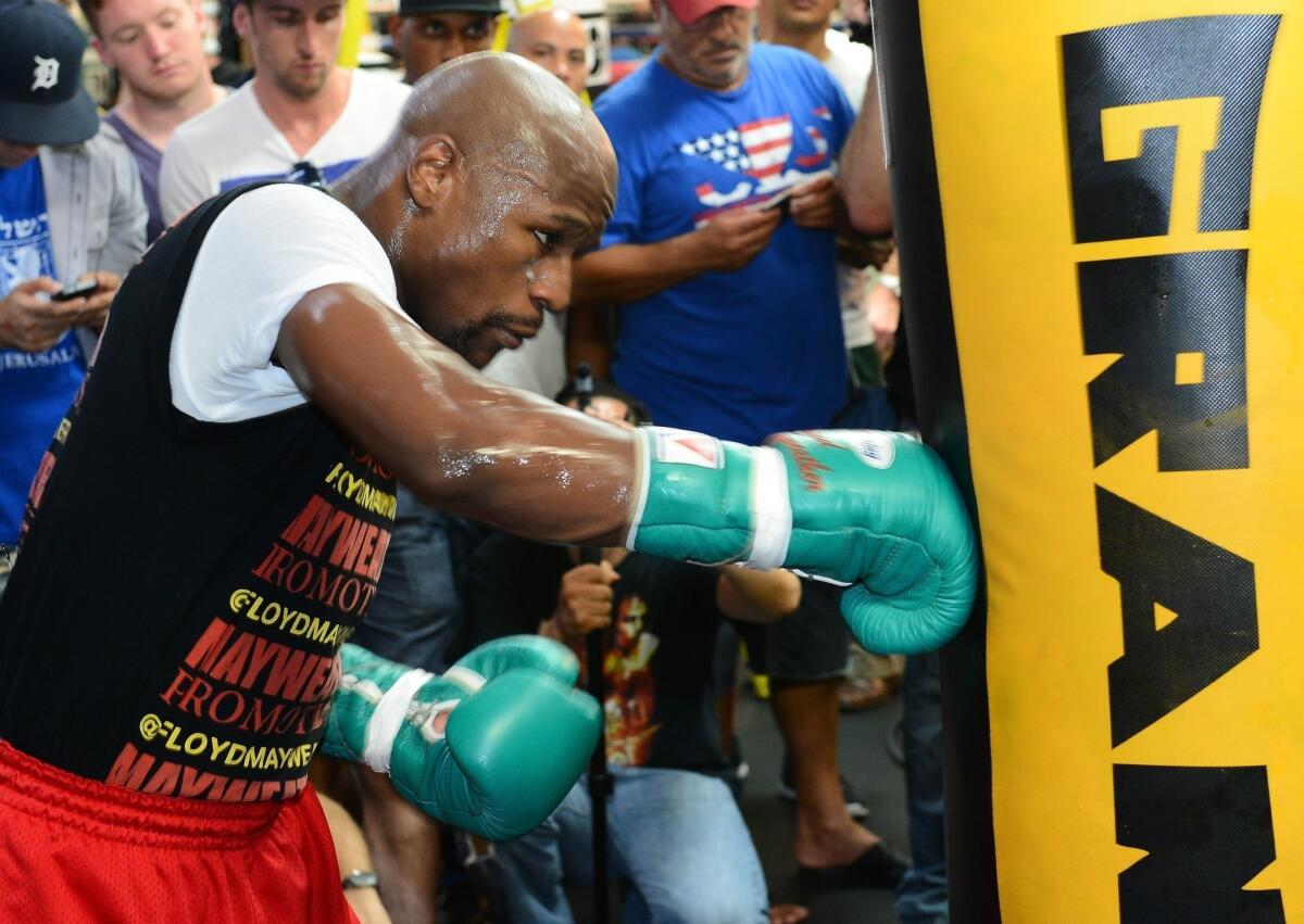 Floyd Mayweather Jr. hits a heavy bag as he works out at the Mayweather Boxing Club on Aug. 28 in Las Vegas.