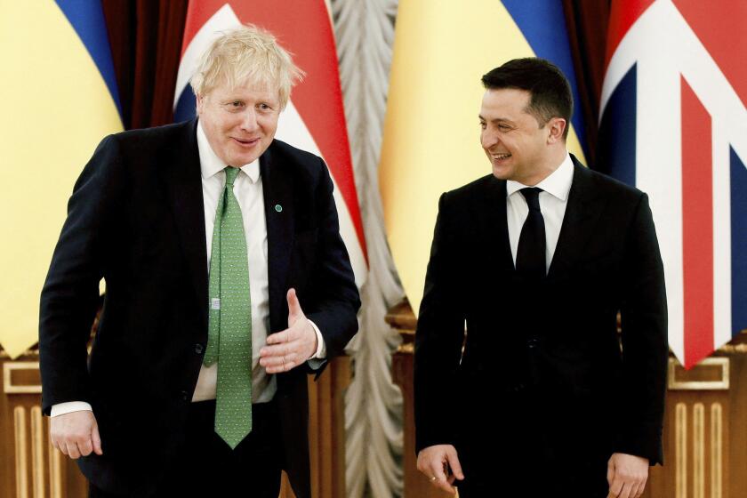 Britain's Prime Minister Boris Johnson, left, reacts with Ukrainian President Volodymyr Zelenskyy, prior to their talks amid rising tension between Ukraine and Russia, at the presidential palace, in Kyiv, Ukraine, Tuesday, Feb. 1, 2022. (Peter Nicholls/Pool Photo via AP)