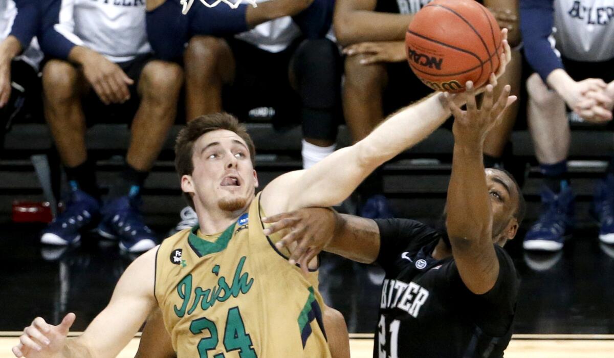 Notre Dame forward Pat Connaughton (24) grabs the ball from Butler forward Roosevelt Jones (21) in the second half of the Irish's 67-64 overtime victory Saturday.