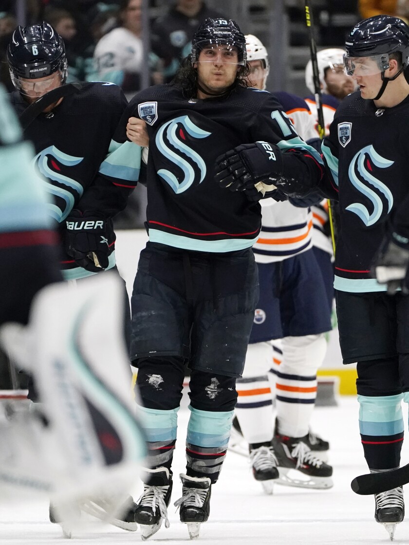 Seattle Kraken's Brandon Tanev is assisted off the ice after being injured against the Edmonton Oilers in the third period of an NHL hockey game Saturday, Dec. 18, 2021, in Seattle. The Oilers won 5-3. (AP Photo/Elaine Thompson)