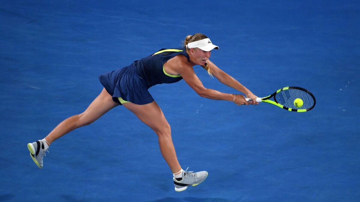 Denmark's Caroline Wozniacki hits a return against Romania's Simona Halep during their match in Melbourne.