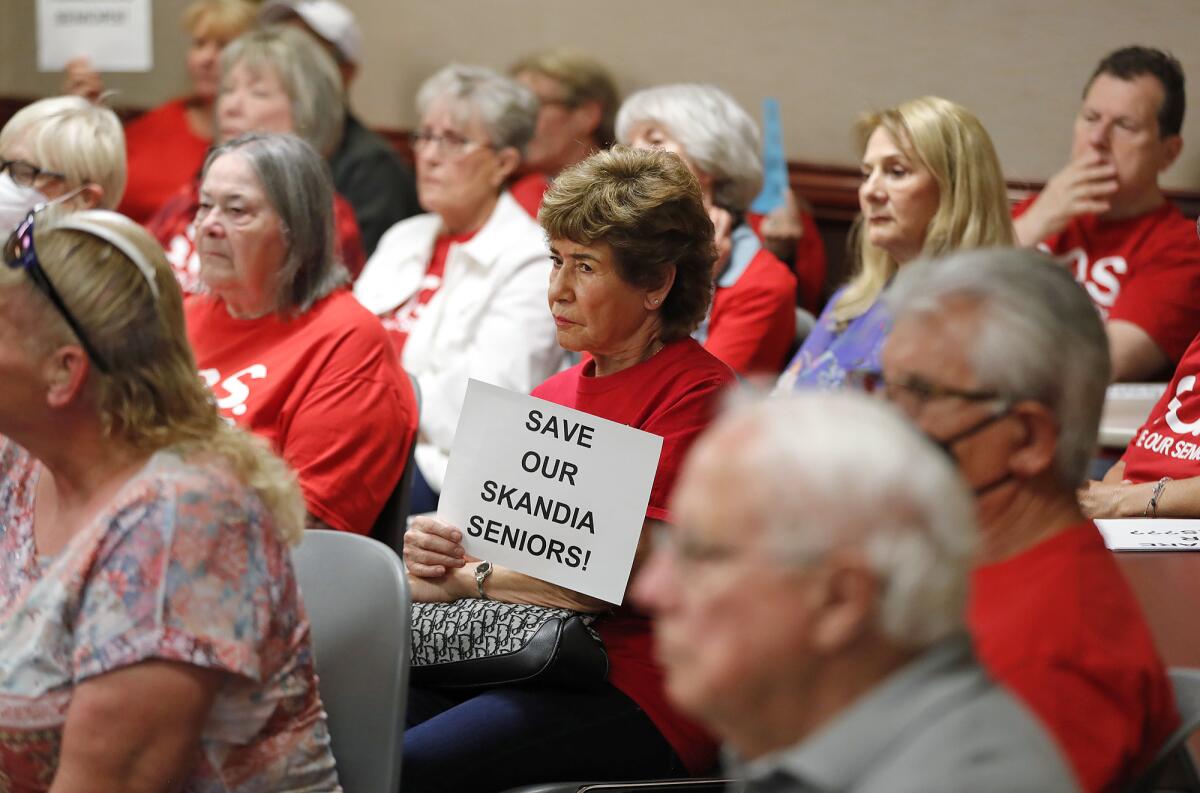 Skandia mobile home residents wear solidarity red shirts, hold signs.