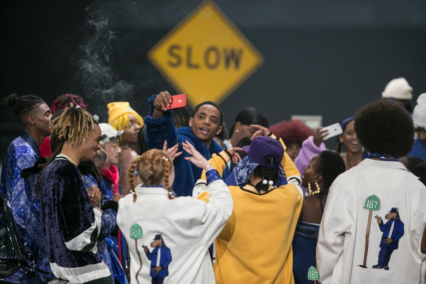 Cordell Broadus, center, son of Snoop Dogg, takes a photo during the finale of the Joyrich X Snoop Dogg collection. The younger Broadus made his runway modeling debut at the June 10, 2017, show and was the creative director of the capsule collection.