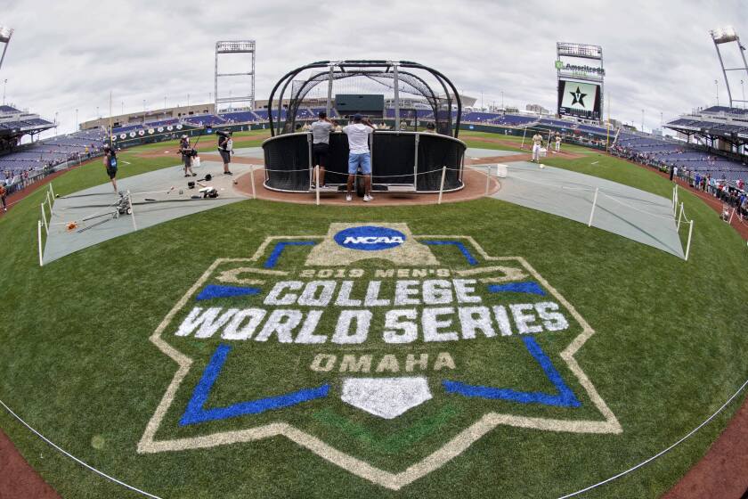 FILE - In this June 14, 2019, file photo, the College World Series logo is partially painted at TD Ameritrade Park in Omaha, Neb., as Vanderbilt players practice ahead of their College World Series game against Louisville. A group of Power Five coaches led by Michigan’s Erik Bakich is proposing a later start to the college baseball season to trim expenses in the post-coronavirus era, make the game more fan friendly and reduce injury risk to players. (AP Photo/Nati Harnik, File)