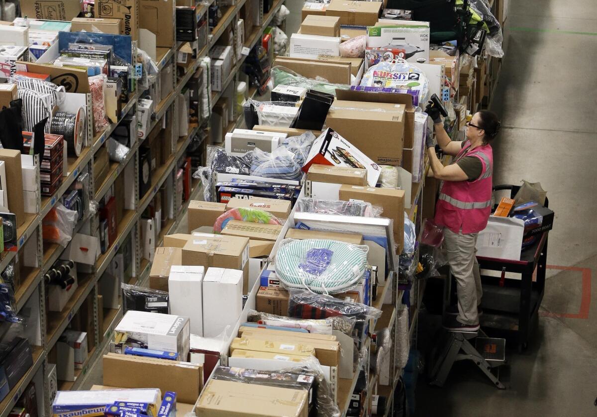 A worker fills orders at the Amazon fulfillment center in Lebanon, Tenn. on Monday. Stocks dipped on weak retail sales reports and slowing economy in China.