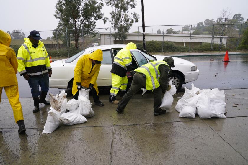 San Diego, CA - February 01: On Thursday, February 1, 2024, in San Diego, CA, Richard Lamont drove up to city sandbag pickup station on 65th Street and Broadway in Encanto where city workers in the rain loaded his vehicle with 10 sandbags. (Nelvin C. Cepeda / The San Diego Union-Tribune)