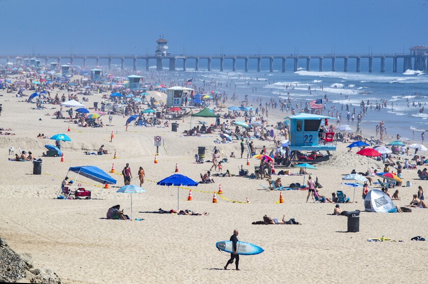 Thousands of beachgoers enjoy a warm, sunny day in Huntington Beach on April 25 amid state-mandated stay-at-home orders designed to stave off the coronavirus pandemic.