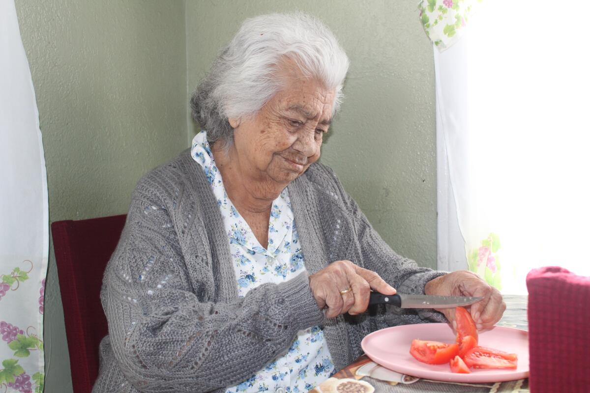 Desde su hogar en Compton Maria Antonia ayuda en la cocina cortando tomates. (Foto del 2/13/2021).