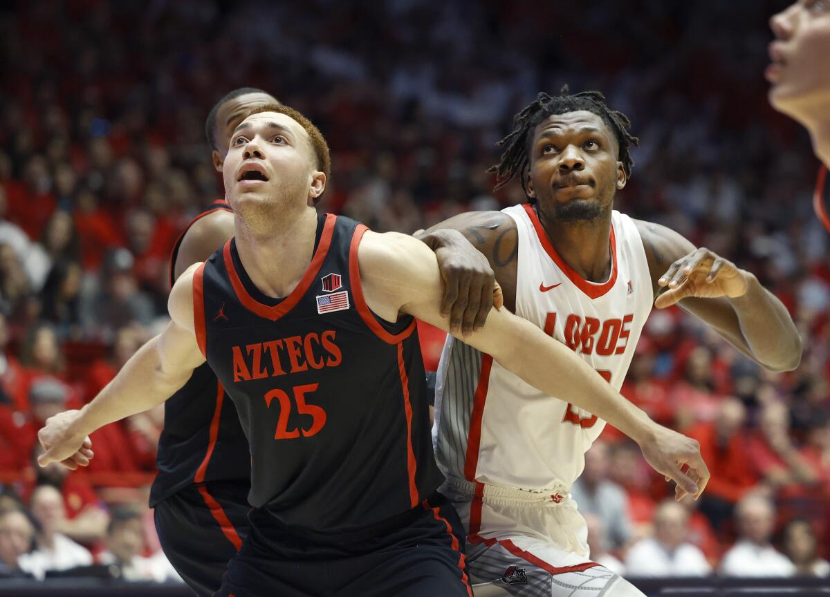 San Diego State forward Elijah Saunders, left, and New Mexico center Nelly Junior Joseph
