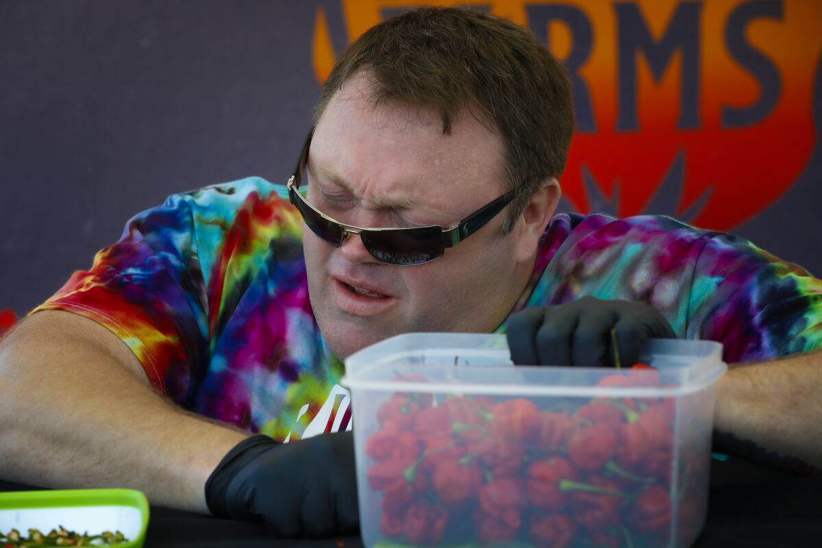 Greg Foster dropped to his knees in his attempt to set a world record of eating 123 Carolina Reaper chilis.