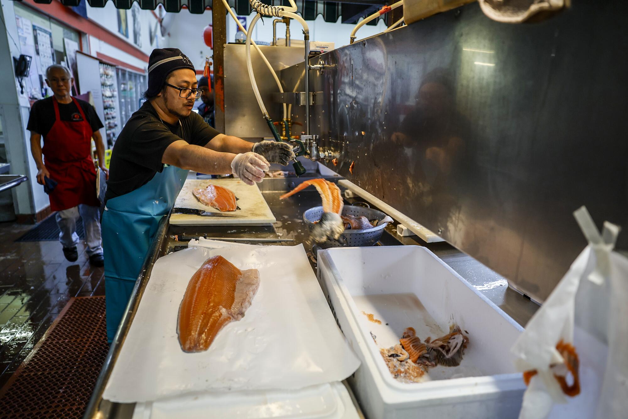 A worker prepares raw fish. 