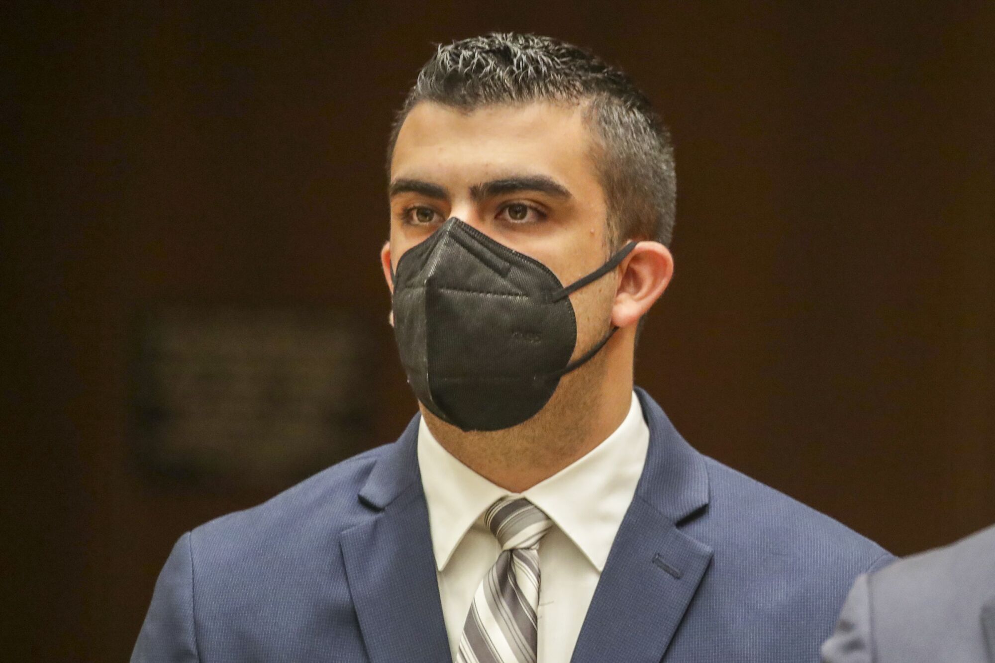 Daniel Nogueira wears a mask and a suit