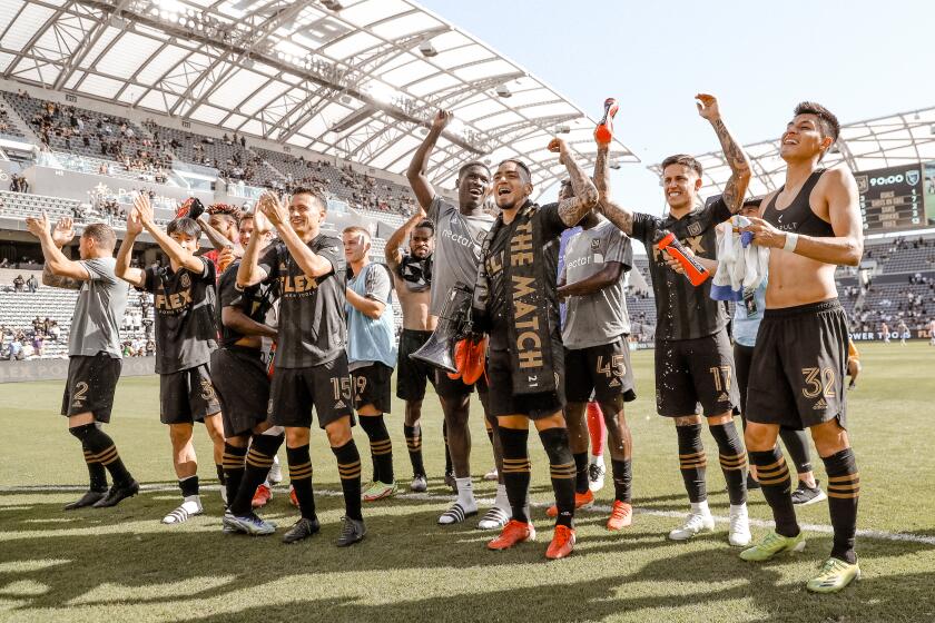 Cristian Arango, third from the right wearing a man of the match scarf, and his LAFC teammates celebrate after defeating the San Jose Earthquakes on Saturday, Oct. 16, at Banc of California Stadium in Los Angeles.