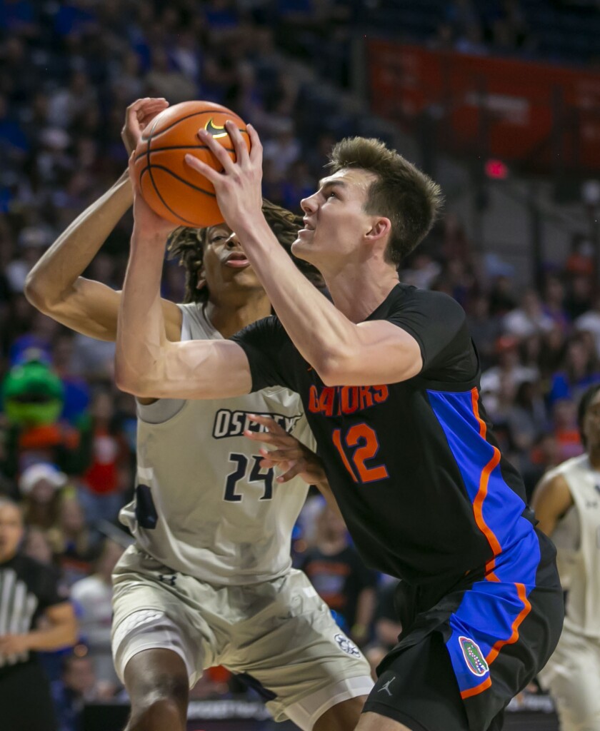 Florida forward Colin Castleton (12) drives on North Florida forward Jadyn Parker (24) during the first half of an NCAA college basketball game Wednesday, Dec. 8, 2021, in Gainesville, Fla. (AP Photo/Alan Youngblood)