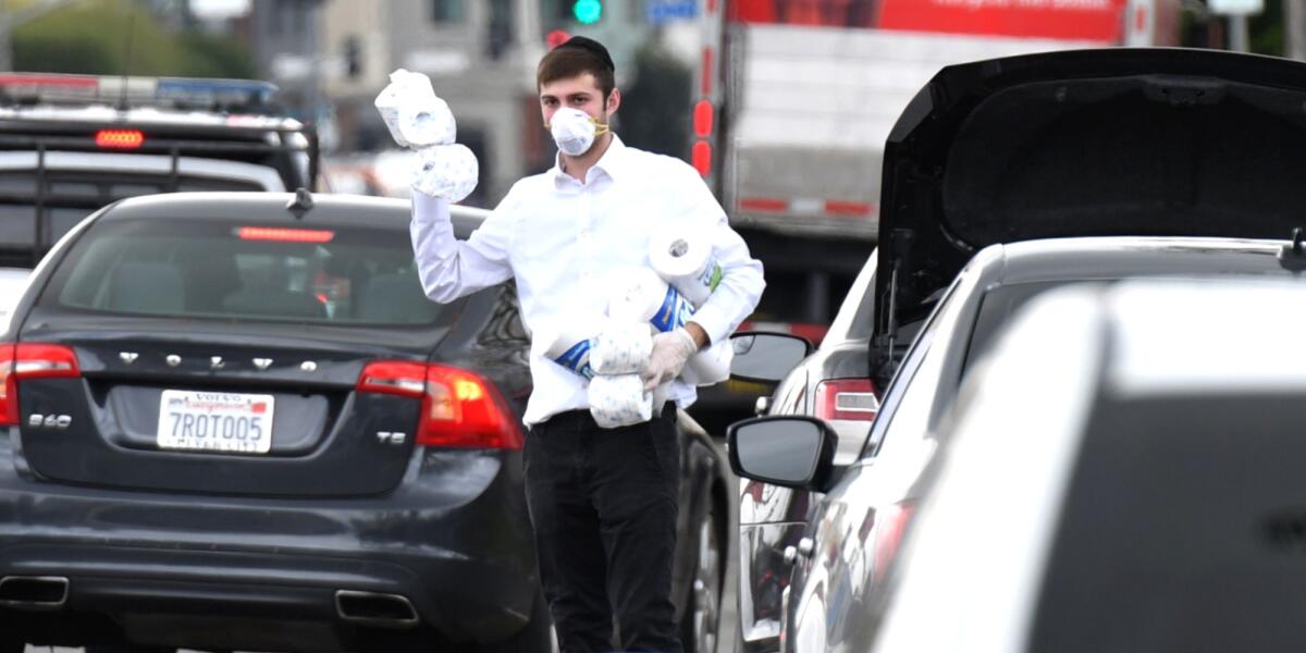 A man in Los Angeles offers free toilet paper and paper towels to motorists Tuesday.