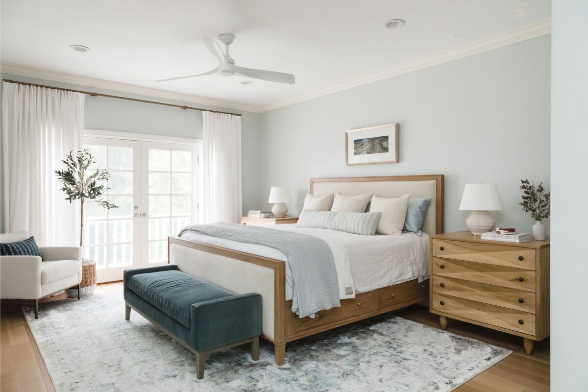 A bedroom provides storage in a bed frame with drawers below the mattress and a nightstand with multiple drawers.